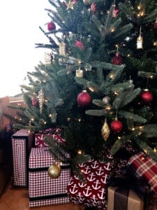 A christmas tree with gifts wrapped beneath it set up for ushering in the holiday season